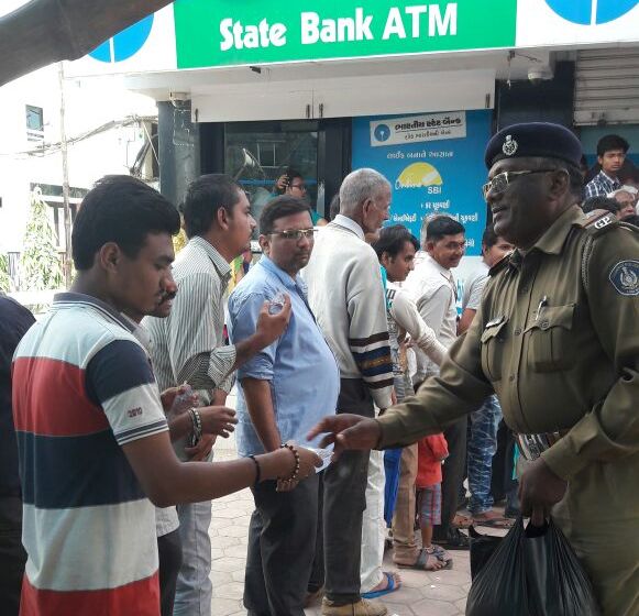 vadodara Police distribute water to people waiting outside the banks